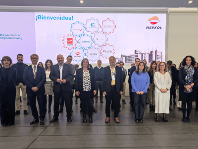 Foto de grupo que muestra a los representantes de las empresas mencionadas de pie. En el fondo de la imagen sale proyectada una diapositiva con los logos de las empresas participantes en el proyecto Madrid Vuela Sostenible